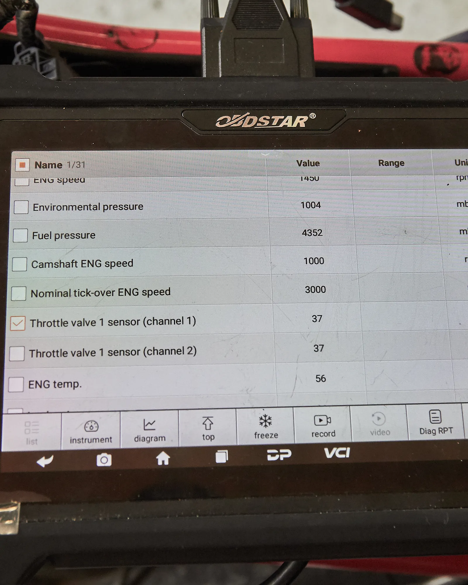 Tester diagnostyczny OBDSTAR podłączony do motocykla, na ekranie parametry pracy silnika: obroty, ciśnienie paliwa i temperatura