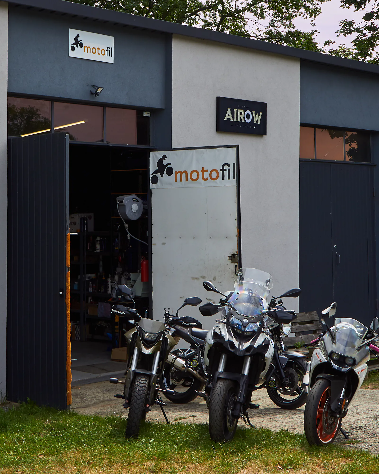 Warsztat motocyklowy Motofil w Krakowie — hala z szyldem Motofil, otwarte wrota i motocykle klientów przed wejściem